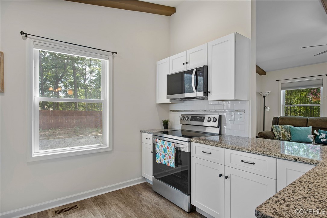 321 Johnson Mill Road Bumpass, VA 23024 - Photo 11 of 33 a kitchen with stainless steel appliances granite countertop a stove a sink and a microwave