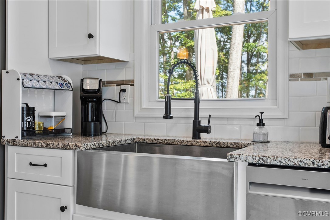 321 Johnson Mill Road Bumpass, VA 23024 - Photo 14 of 33 a kitchen with granite countertop a sink stainless steel appliances white cabinets and a window