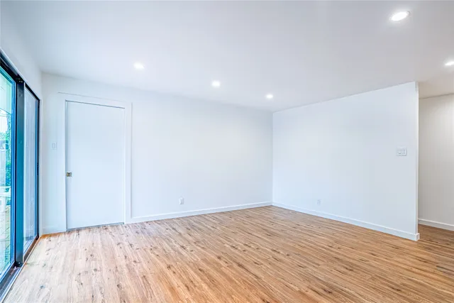 a view of empty room with wooden floor