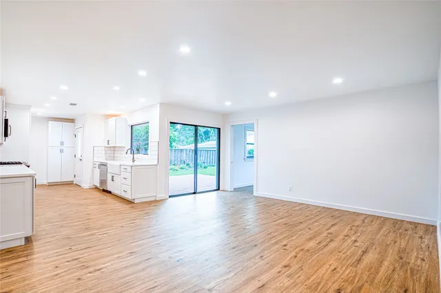 a view of a big room with wooden floor and windows