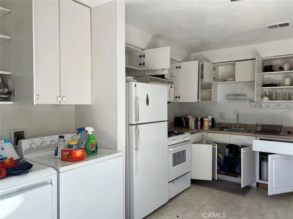 a kitchen with stainless steel appliances a sink a stove a refrigerator a counter space and cabinets