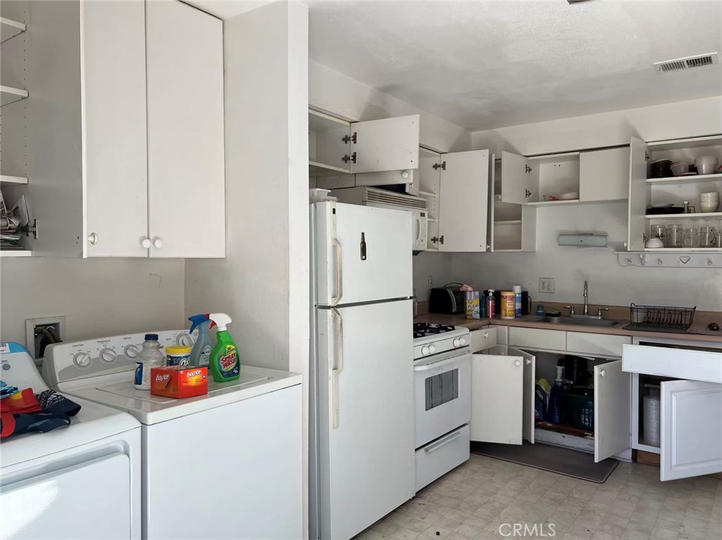 1777 Mitchell Avenue, Unit 92 Tustin, CA 92780 - Photo 5 of 13 a kitchen with stainless steel appliances a sink a stove a refrigerator a counter space and cabinets
