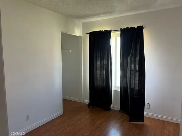 an empty room with wooden floor and closet