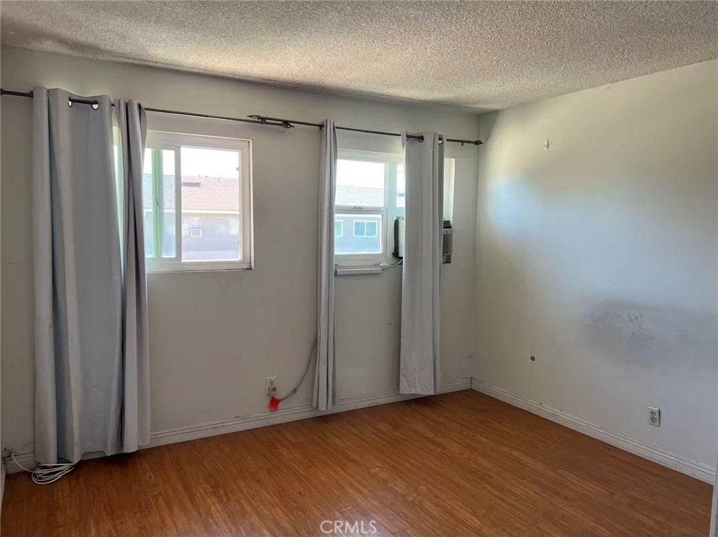 1777 Mitchell Avenue, Unit 92 Tustin, CA 92780 - Photo 9 of 13 an empty room with wooden floor and windows