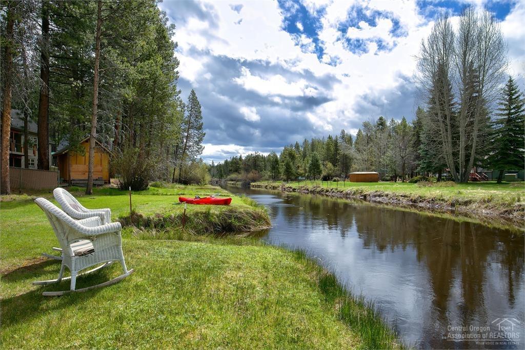 17171 Island Loop Way Bend, OR 97707 - Photo 8 of 25 a view of a lake with couches and wooden fence