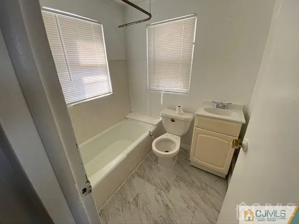 a bathroom with a sink toilet and window