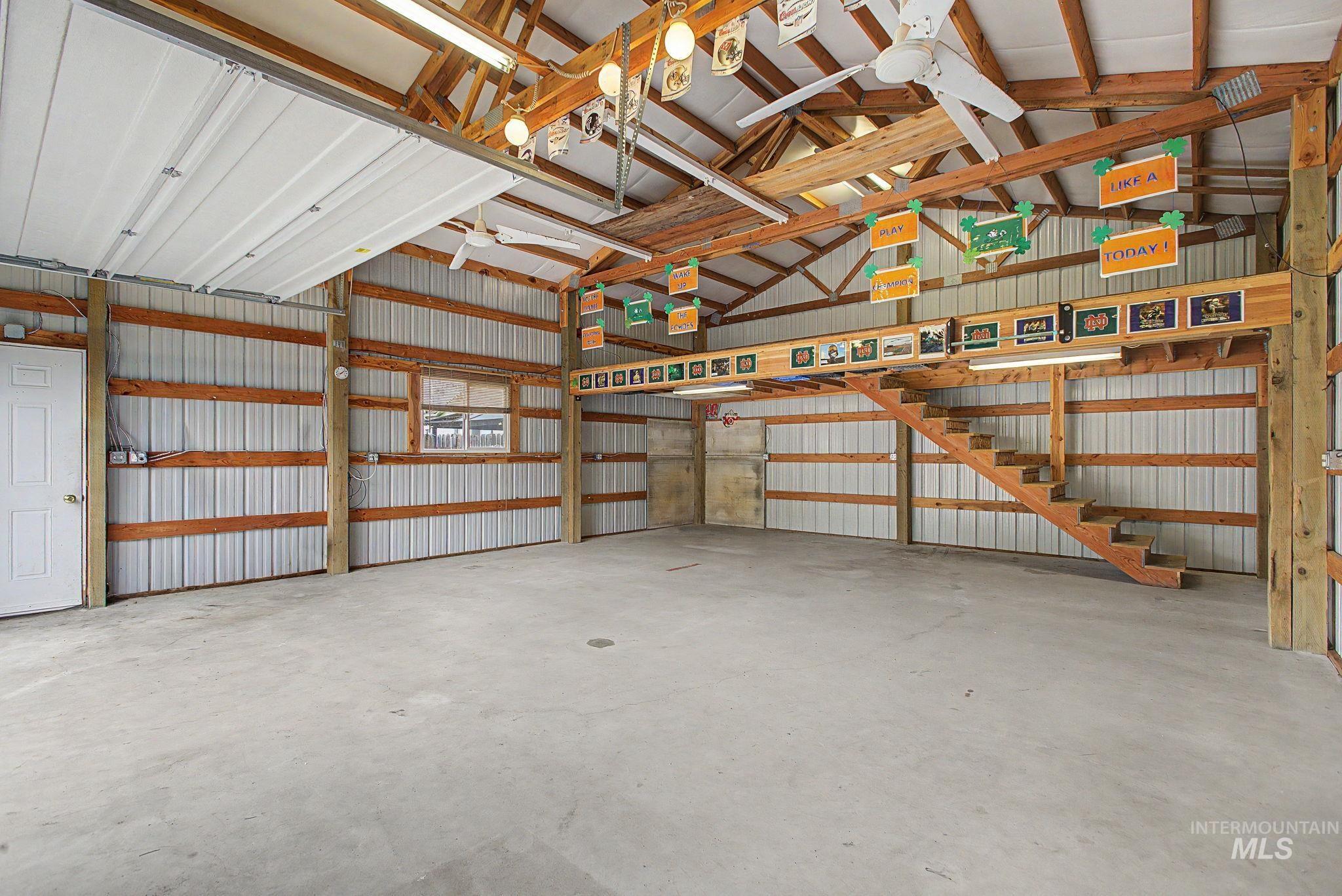 3314 6th Street Lewiston, ID 83501 - Photo 45 of 50 Spacious interior featuring a concrete floor, corrugated metal walls with exposed wooden beams, and a wood-finish staircase leading to an upper platform