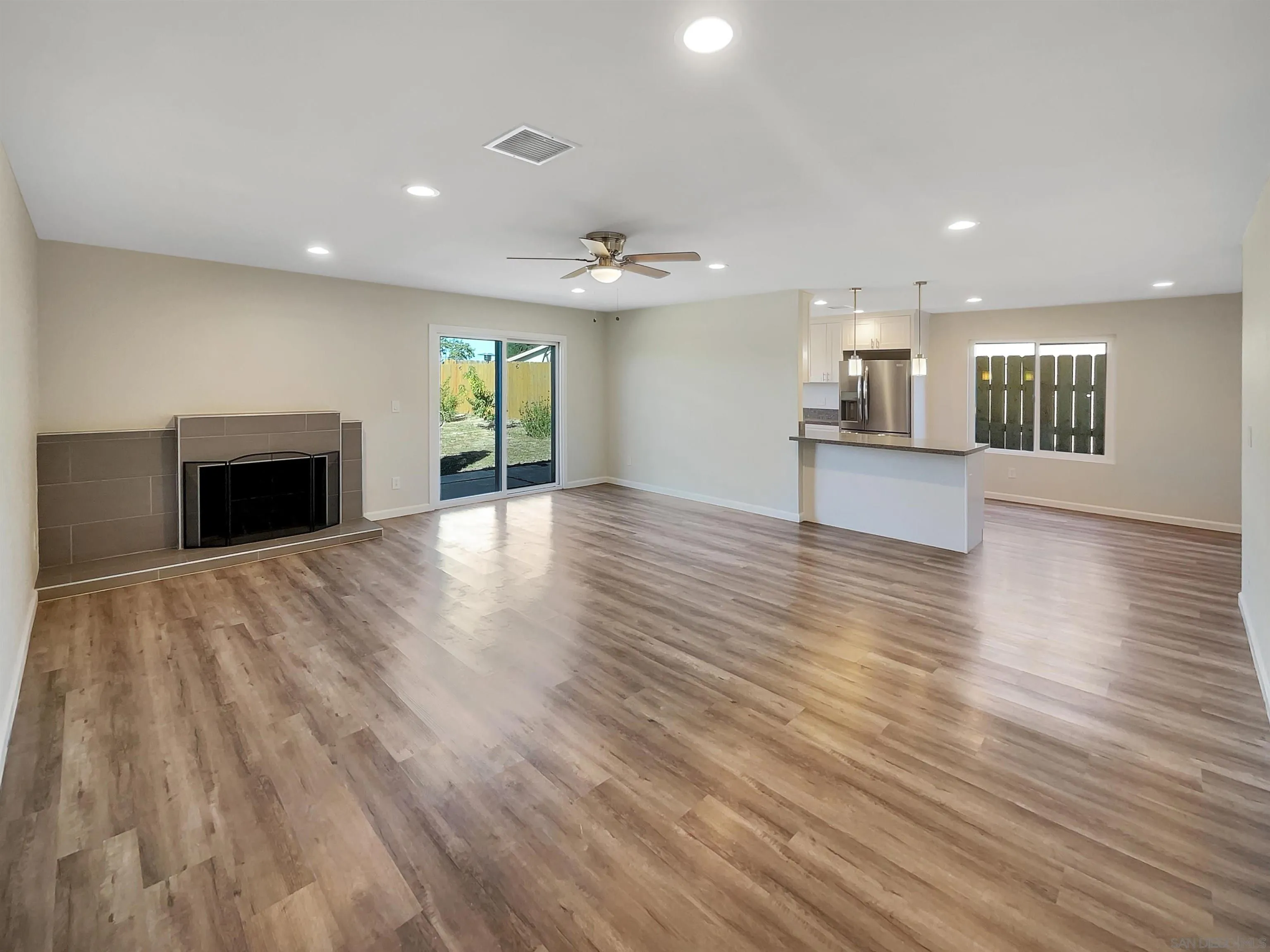 8238 Cacus Street Spring Valley, CA 91977 - Photo 3 of 22 an empty room with wooden floor fireplace and windows