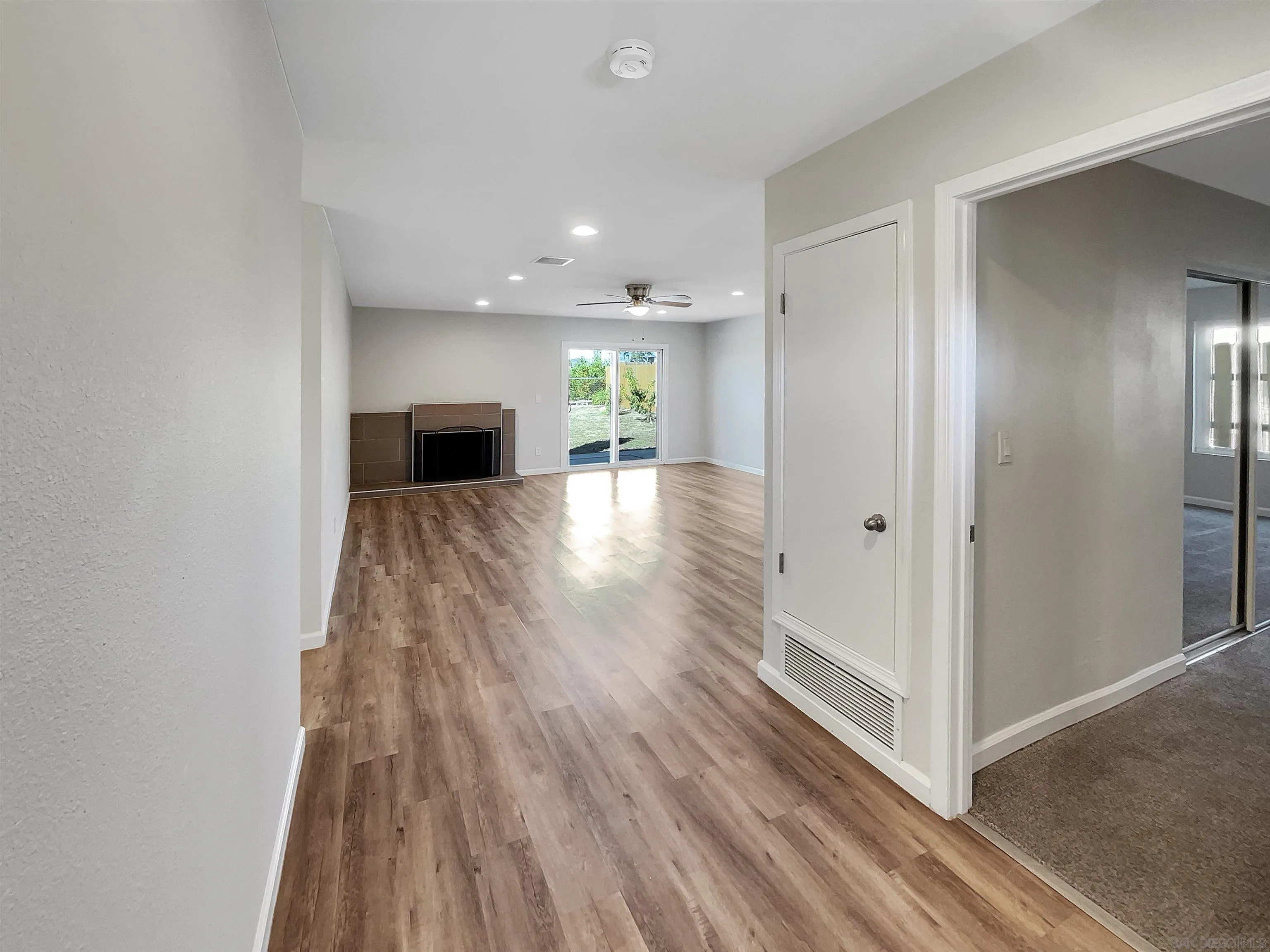 8238 Cacus Street Spring Valley, CA 91977 - Photo 9 of 22 a view of a hallway with wooden floor and a fireplace