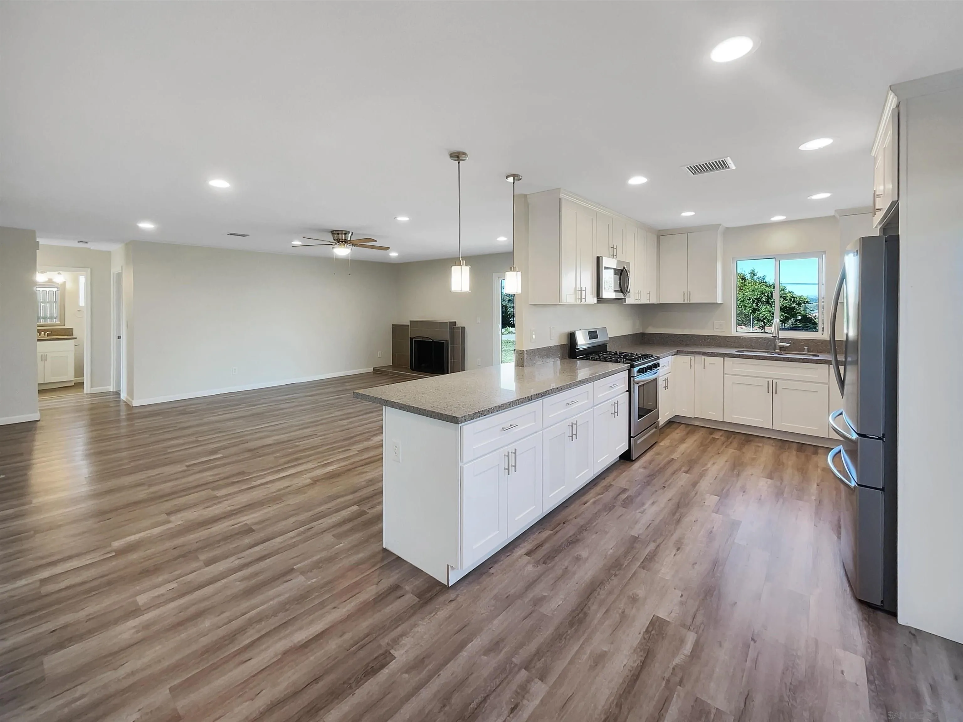 8238 Cacus Street Spring Valley, CA 91977 - Photo 10 of 22 a large kitchen with stainless steel appliances granite countertop a large center island attached withe living room