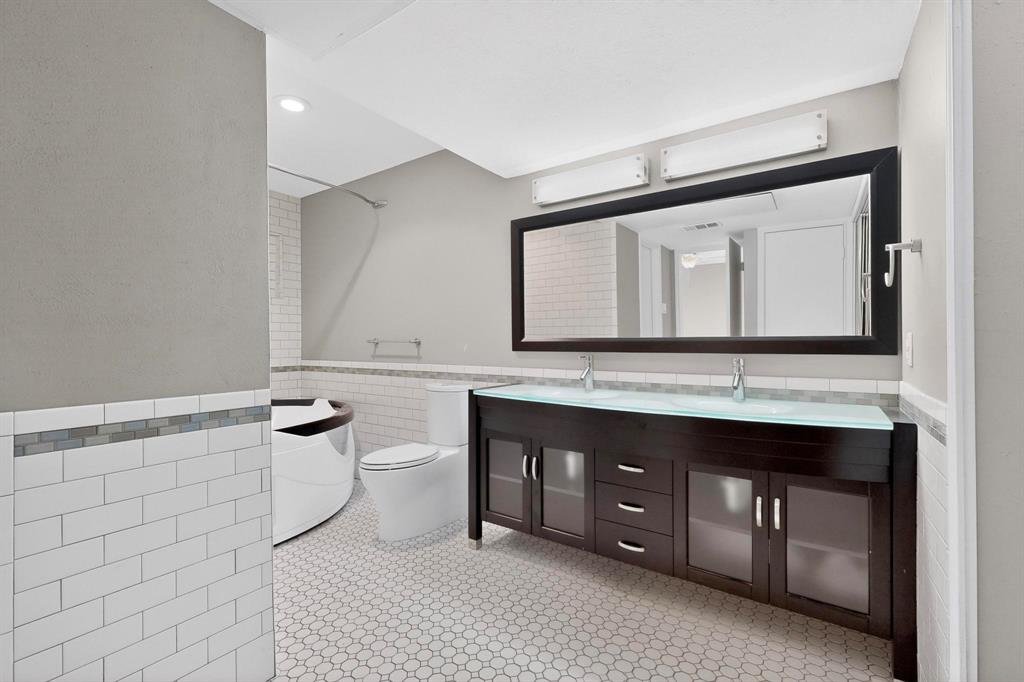 9222 Church Road, Unit 112 Dallas, TX 75231 - Photo 11 of 22 a bathroom with a sink a toilet and mirror