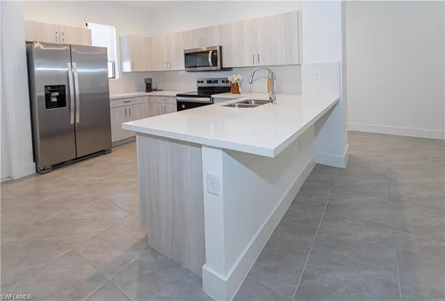 a kitchen with stainless steel appliances a refrigerator sink and microwave