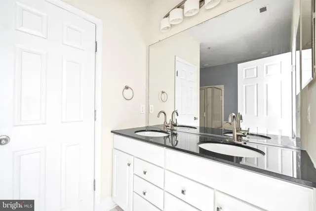 a bathroom with double sink and a mirror