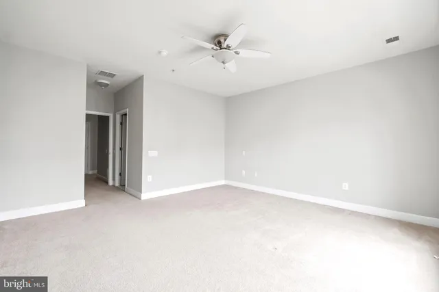 an empty room with a ceiling fan and a window