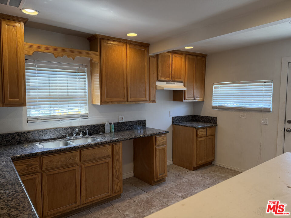 205 West Poplar Street Compton, CA 90220 - Photo 21 of 21 a kitchen with granite countertop cabinets sink and window