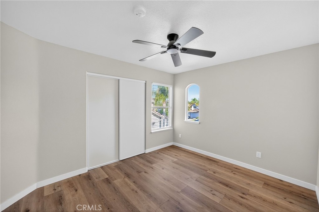 44797 Corte Sanchez Temecula, CA 92592 - Photo 32 of 58 an empty room with wooden floor ceiling fan and windows