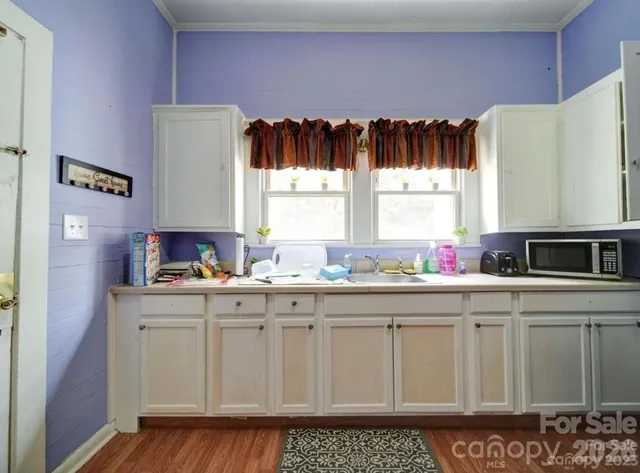 a kitchen with granite countertop a stove a sink and a microwave
