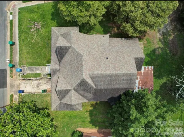 an aerial view of a house with a yard and trees
