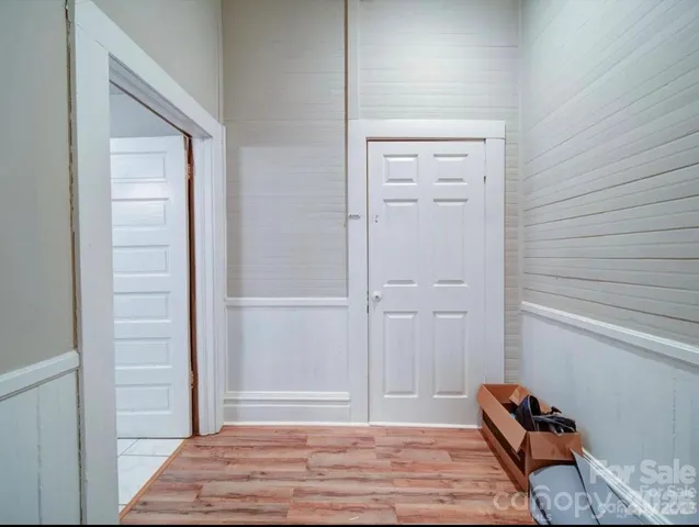 a view of a hallway with wooden floor and closet