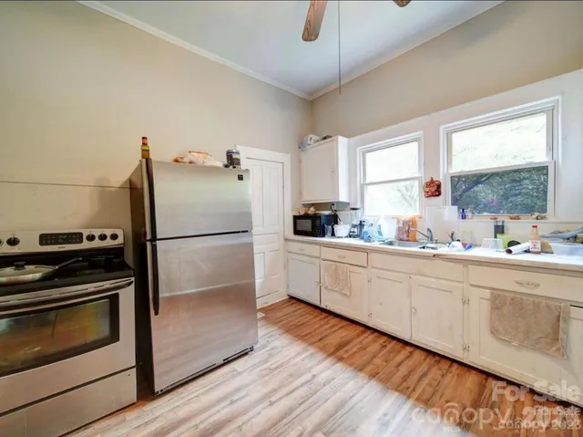 a kitchen with granite countertop a refrigerator stove and sink