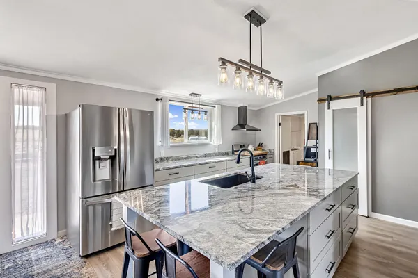 a bedroom with granite countertop a bed a chandelier and dresser