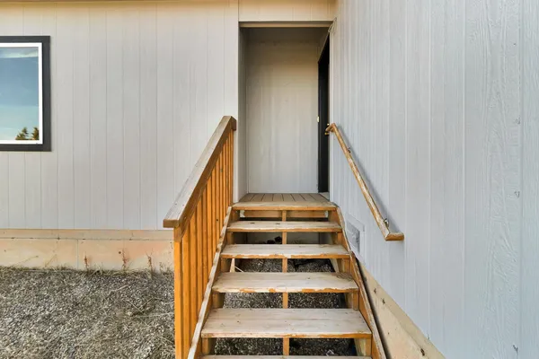 a view of staircase with wooden floor and white walls
