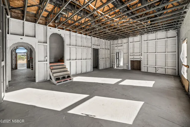 a spacious bedroom with a bed a couch and a large window