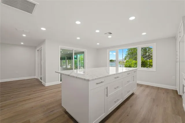 a kitchen with stainless steel appliances granite countertop a large counter top and a wooden floors