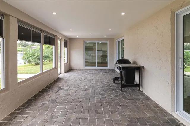 a view of a roof deck with table and chairs a barbeque with wooden floor and fence