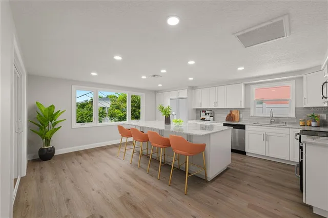 a large white kitchen with a large window