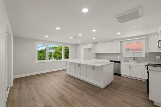 a large kitchen with a lot of counter space and a wooden floor