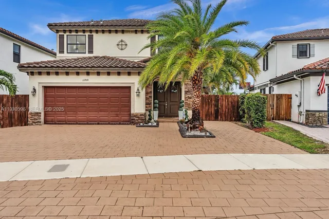 a view of a house with a yard and potted plants