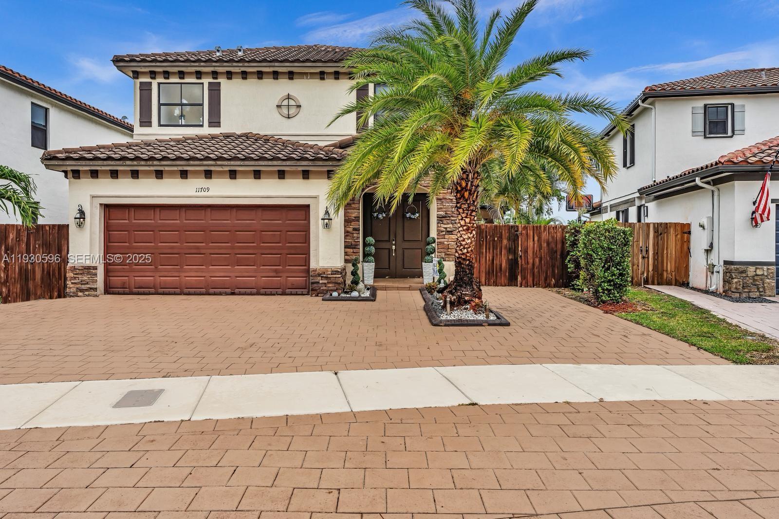 a view of a house with a yard and potted plants