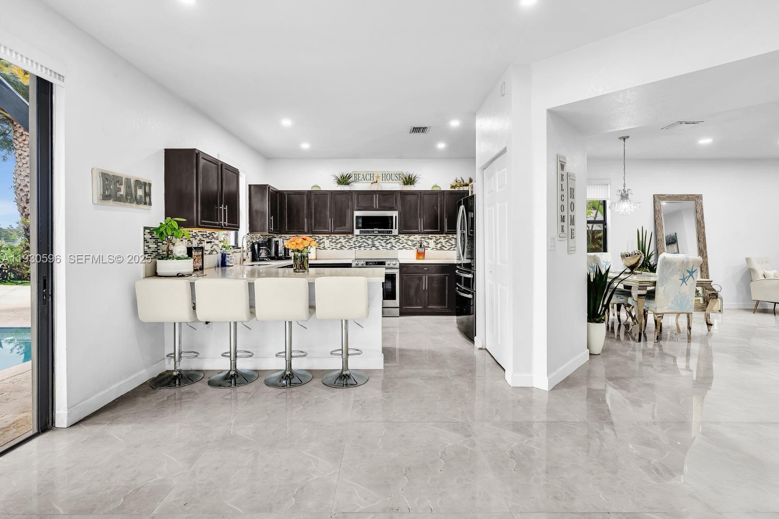 11709 Southwest 253rd Street Homestead, FL 33032 - Photo 11 of 47 a kitchen with stainless steel appliances kitchen island granite countertop a refrigerator and a sink