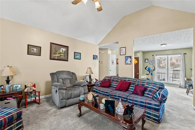 a living room with furniture a fireplace and a large window