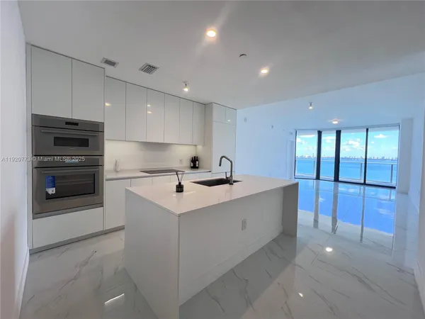 a kitchen with stainless steel appliances a sink stove and refrigerator