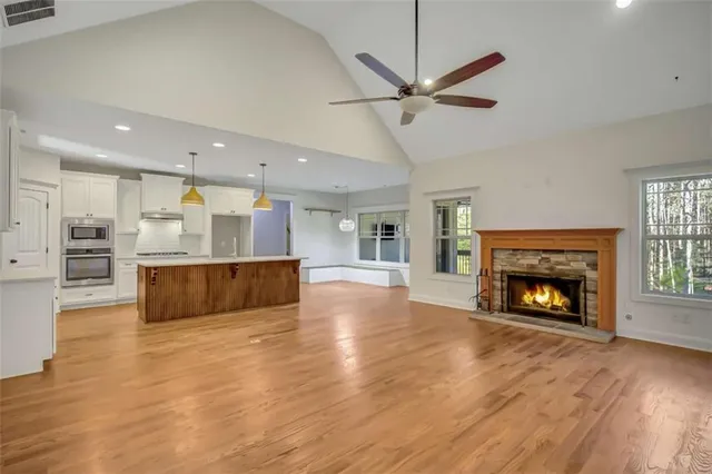 a view of a livingroom with a ceiling fan and hardwood floor