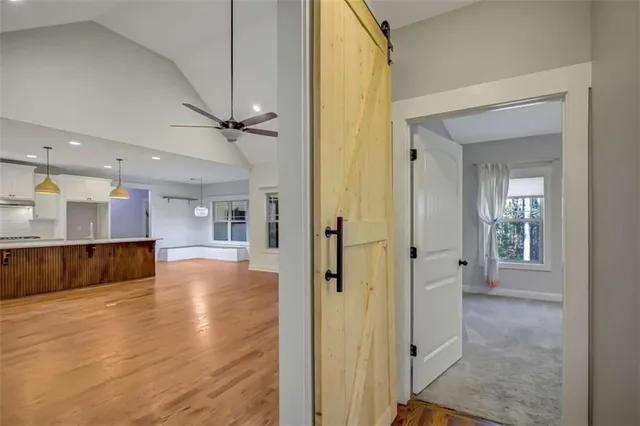 an empty room with chandelier fan and windows