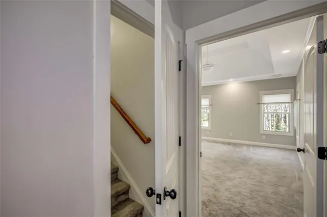 a view of an empty room with wooden floor and windows