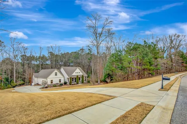 an aerial view of a house with outdoor space and trees all around