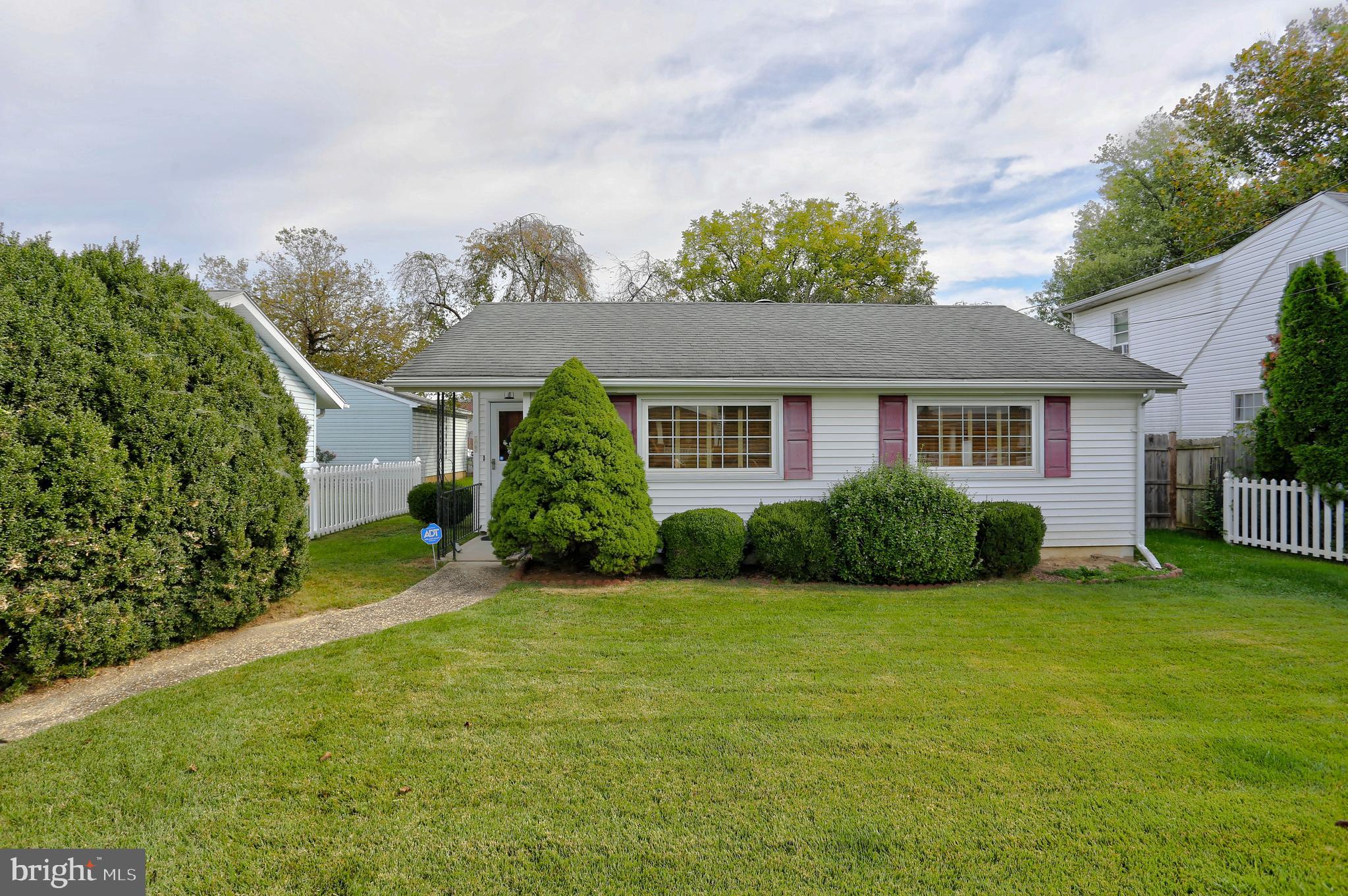 a view of a house with a yard and potted plants