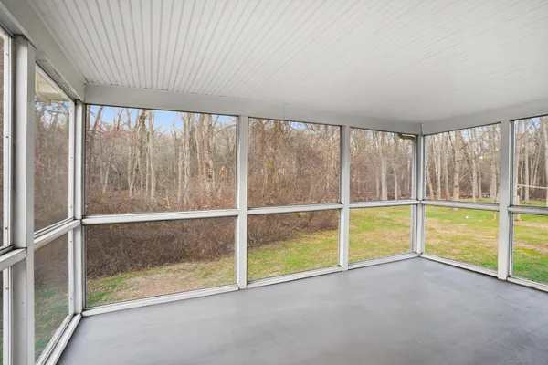 a view of an empty room with a window and fire place