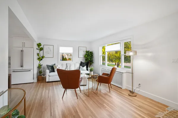 a kitchen with stainless steel appliances a dining table chairs and a refrigerator