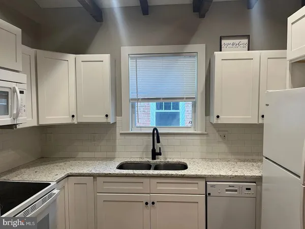 a kitchen with cabinets appliances a sink and a window