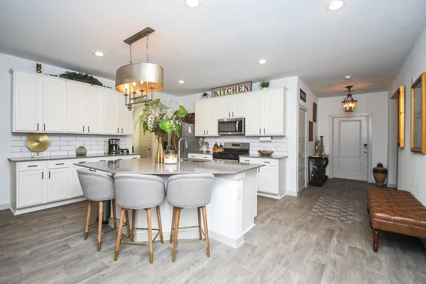 a kitchen with a dining table chairs refrigerator and microwave