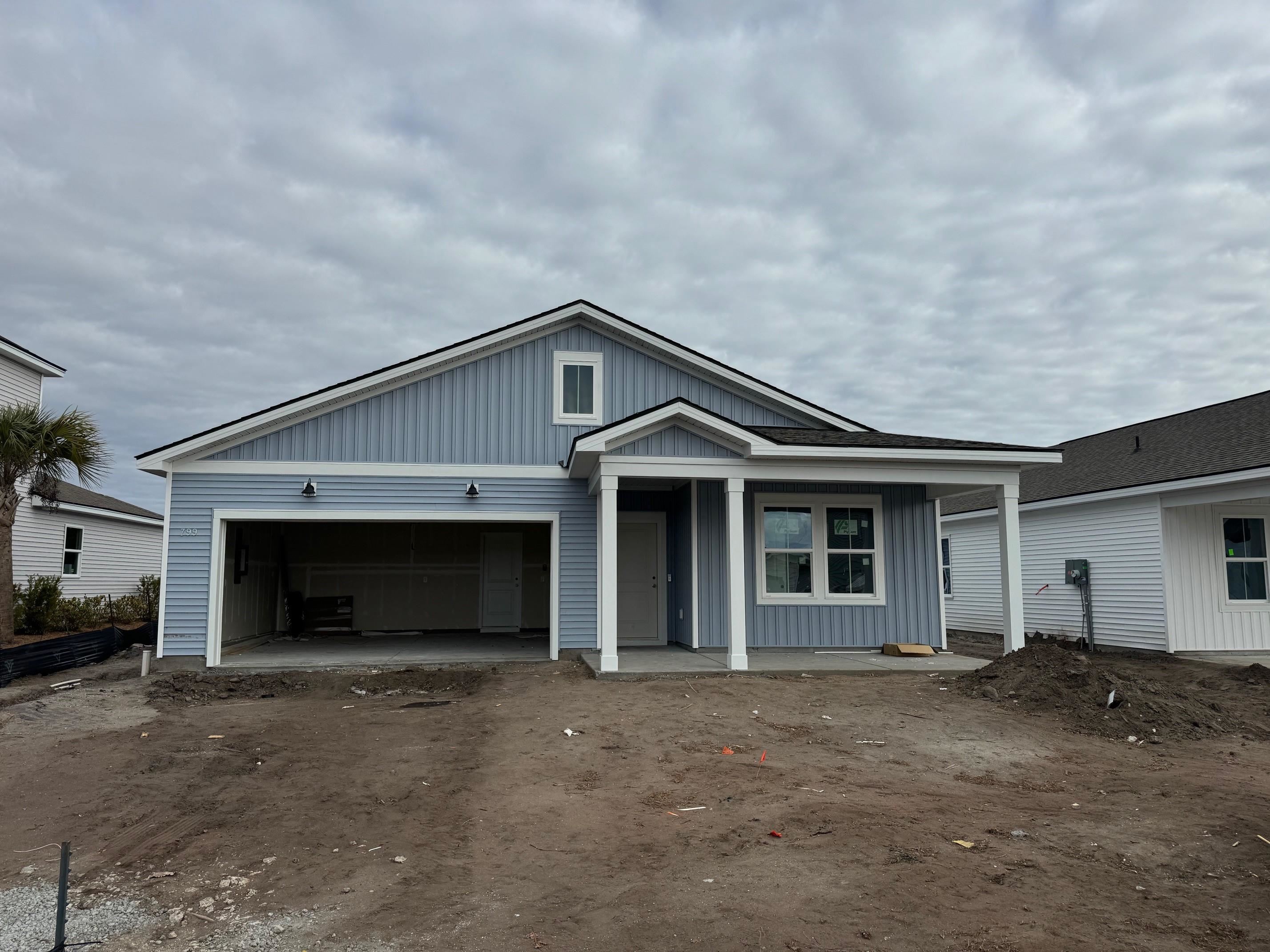799 Laconic Drive Myrtle Beach, SC 29588 - Photo 2 of 21 View of front of home featuring a patio, dirt driveway, and an attached garage