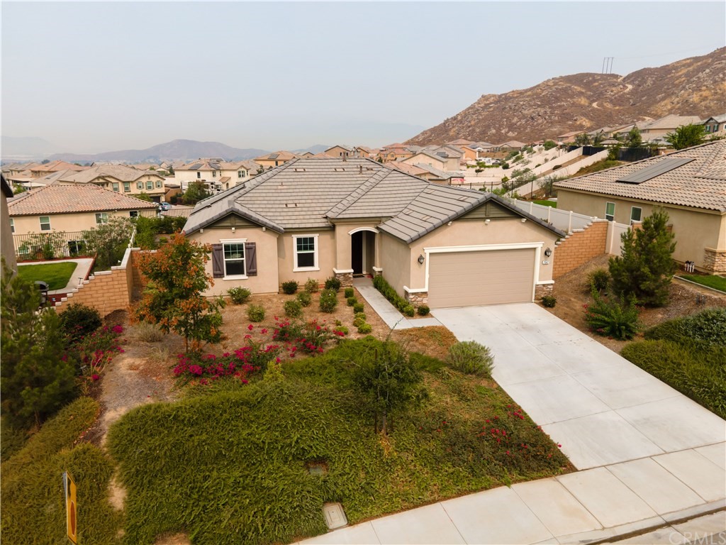7547 Spring Mountain Road Riverside, CA 92507 - Photo 1 of 1 a view of a white house next to a yard with plants and trees
