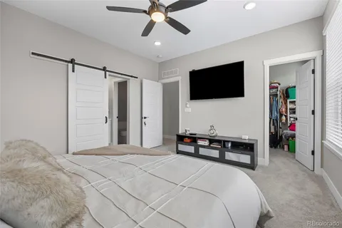 a bedroom with a bed a flat screen tv and a couch