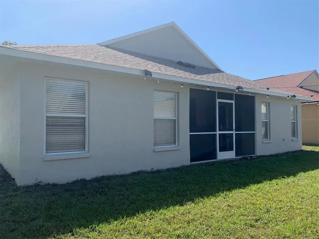 a view of an house with backyard and porch