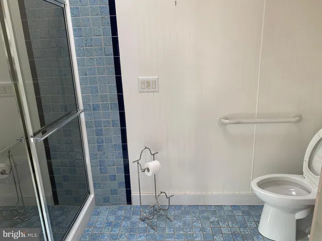 a bathroom with a granite countertop toilet and a sink